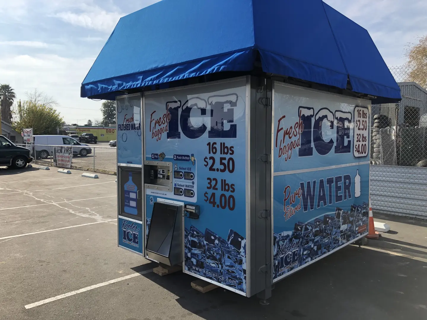 Blue-roofed ice kiosk in parking lot